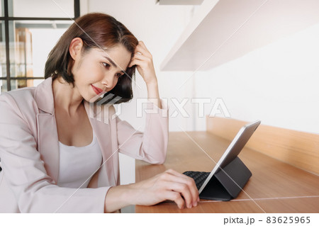 Happy working woman is using a tablet in the office. Happy working woman is using a tablet in the office. 83625965