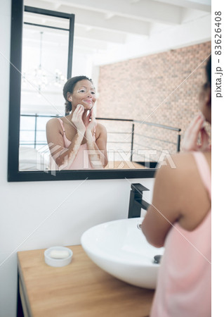A woman in pink lingerie in a bathroom while doing beauty procedures A woman in pink lingerie in a bathroom while doing beauty procedures 83626408