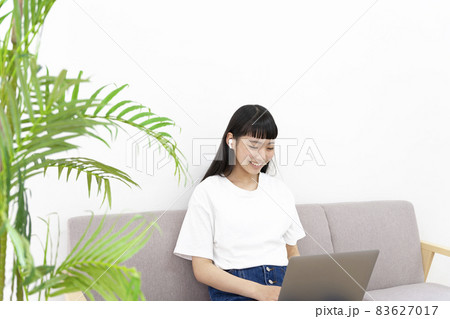 ソファーに座りパソコンを操作する女性イメージ ソファーに座りパソコンを操作する女性イメージ 83627017