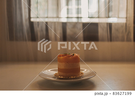 Orange fruit cake in a cup served on white dish. Orange fruit cake in a cup served on white dish. 83627199
