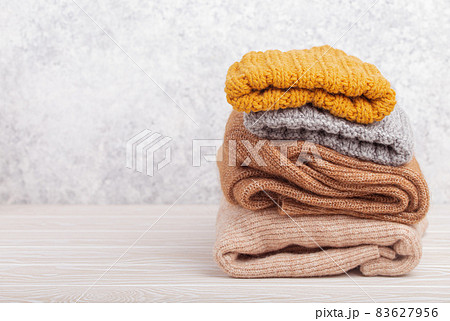 Pile of warm knitted clothes copy space 83627956