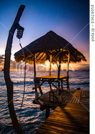 Sunset over wooden beach bar in sea and hut on pier in koh Mak island, Trat, Thailand Sunset over wooden beach bar in sea and hut on pier in koh Mak island, Trat, Thailand 83628058