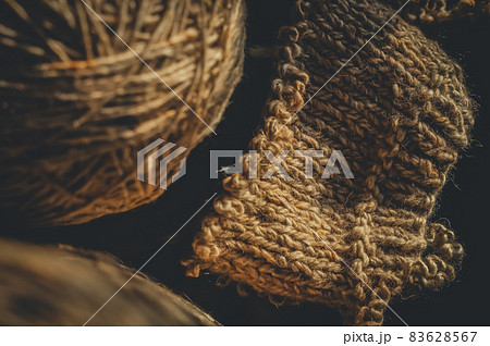 Knitting project close-up. Knitting a warm sweater. Dark background, vertical composition, selective focus 83628567