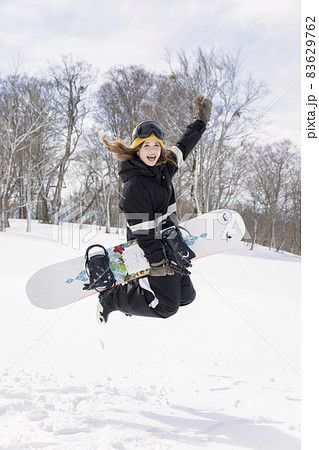 スキー場でジャンプをする若い女性 83629762