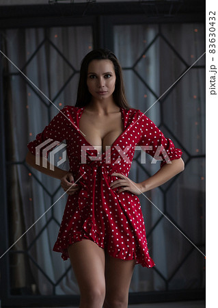 Stylish young woman in sexy dress standing with hand on waist Stylish young woman in sexy dress standing with hand on waist 83630432