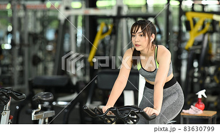 Sportswoman exercising on bicycle at the gym. Sportswoman exercising on bicycle at the gym. 83630799