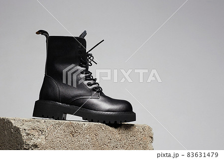 Black boot on a cinder block. fashion shoes still life 83631479