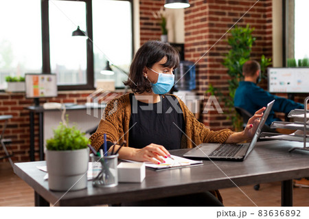 Businesswoman with medical protective face mask against coronavirus 83636892