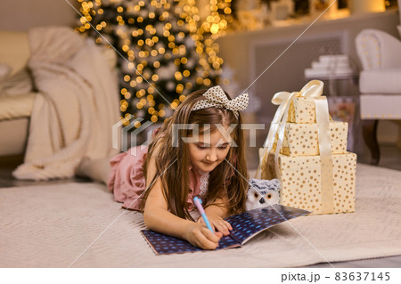 Cute little child girl writes the letter to Santa Claus Cute little child girl writes the letter to Santa Claus 83637145