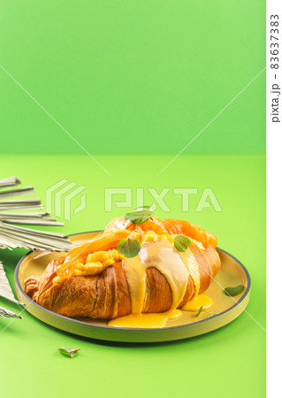 Croissant with salmon and avocado sauce on green Croissant with salmon and avocado sauce on green 83637383