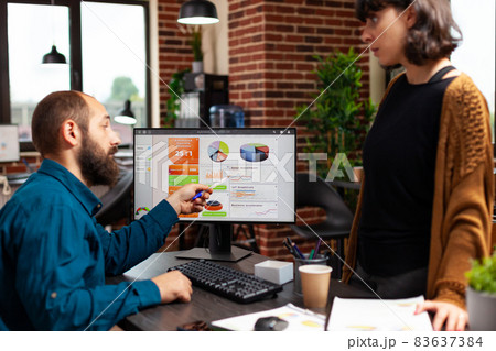 Businessman explaining marketing strategy to woman manager showing company data chart 83637384