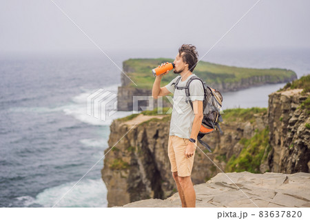 Male tourist on the background of beautiful rocks and the sea. Hiking concept. Tobizin cape. Vladivostok, island Russky. Sea of Japan. Primorye. Primorsky krai. Nature of Russia. Tourism and travel in Male tourist on the background of beautiful rocks and the sea. Hiking concept. Tobizin cape. Vladivostok, island Russky. Sea of Japan. Primorye. Primorsky krai. Nature of Russia. Tourism and travel in 83637820