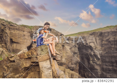 Dad and son tourists on the background of beautiful rocks and the sea. Hiking concept. Tobizin cape. Vladivostok, island Russky. Sea of Japan. Primorye. Primorsky krai. Nature of Russia. Tourism and 83642291