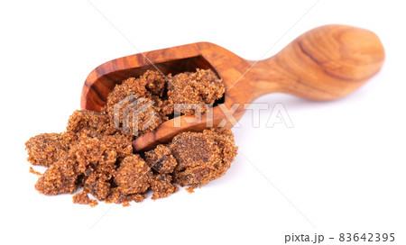 Muscovado sugar in wooden scoop, isolated on white background. Barbados sugar, khandsari or khand. 83642395