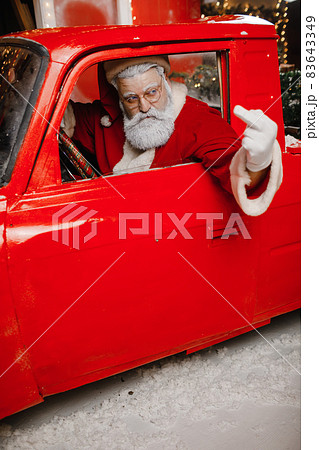 Santa Claus is preparing for Christmas. Angry, displeased, annoyed, stylish Santa Claus driving a 83643349