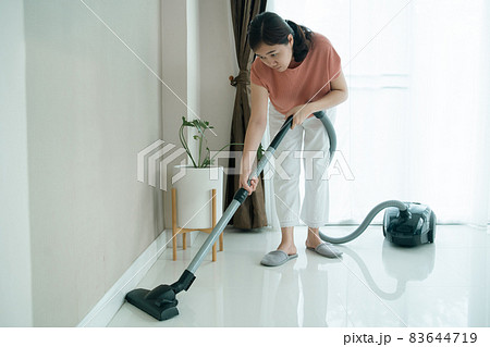Woman using vacuum machine to cleaning living room. 83644719