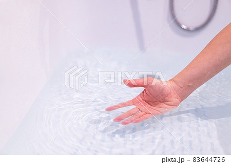 Woman checking a water temperature. 83644726