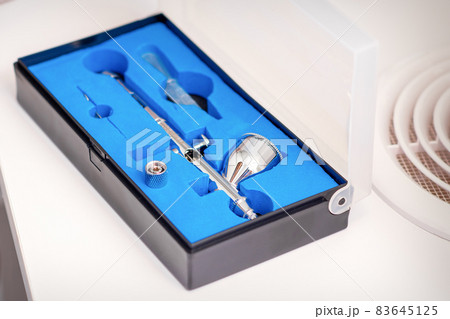 Close up of new clean airbrush tool in the blue box. Close up of new clean airbrush tool in the blue box. 83645125
