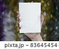 A woman holding white booklet 83645454