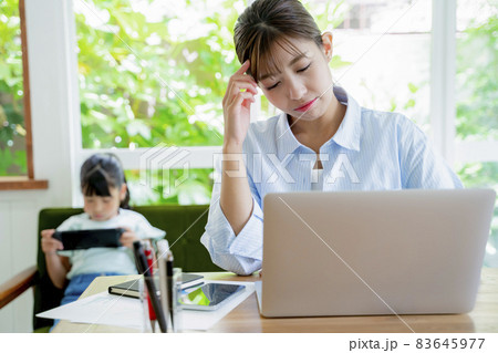 自宅で仕事をする母親とゲームをする子供 83645977