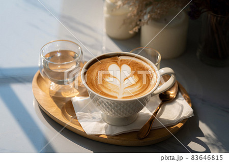 Hot coffee latte with latte art milk foam in cup mug on black wood desk on  top view. As breakfast In a coffee shop at the cafe,during business work  concept Stock Photo