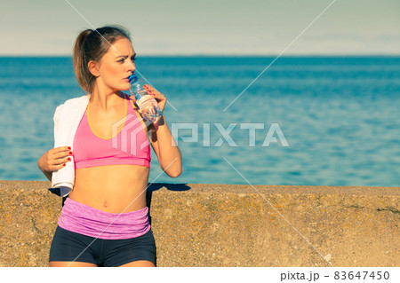 Woman drinking water after sport gym outdoor Woman drinking water after sport gym outdoor 83647450