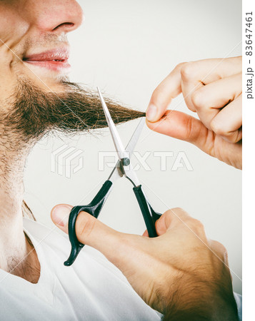Man cutting his beard 83647461