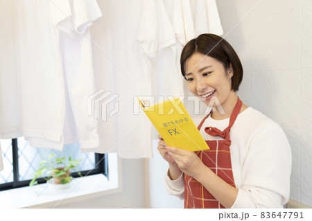風呂場に干したシャツとFXの本を読む女性 風呂場に干したシャツとFXの本を読む女性 83647791