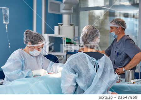 Concentrated Surgical team operating a patient in an operation theater. Well-trained anesthesiologist with years of training with complex machines follows the patient throughout the surgery 83647869