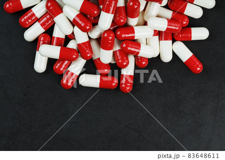 Pills with drugs are scattered on a black background Pills with drugs are scattered on a black background 83648611