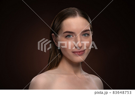 Headshot portrait of happy girl with natural make up and bare shoulders. Healthy pure skin model isolated on black background. Natural make up concept. Spa and beautiful concept Headshot portrait of happy girl with natural make up and bare shoulders. Healthy pure skin model isolated on black background. Natural make up concept. Spa and beautiful concept 83648753
