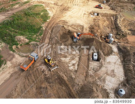 Laying a concrete well ring and sewer pipe at construction site. Earthworks Laying a concrete well ring and sewer pipe at construction site. Earthworks 83649930