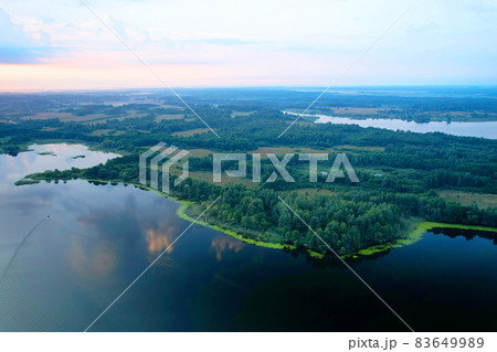 Lake among green trees in the countryside.  83649989