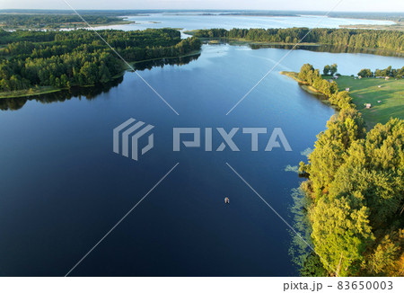 Lake among green trees in the countryside.  83650003