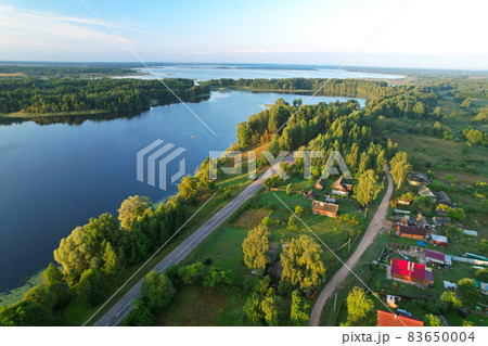 Lake among green trees in the countryside.  83650004