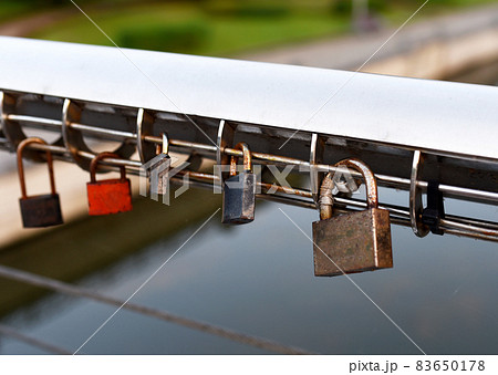 Padlock on Lovers Lock Bridge. Husband and wife during the wedding hung a padlock on the fence Padlock on Lovers Lock Bridge. Husband and wife during the wedding hung a padlock on the fence 83650178