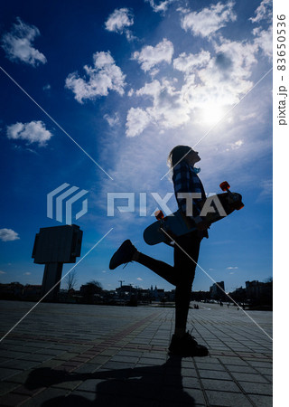 Beautiful young skater woman riding on her longboard in the city. 83650536
