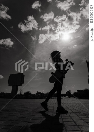 Beautiful young skater woman riding on her longboard in the city. 83650537