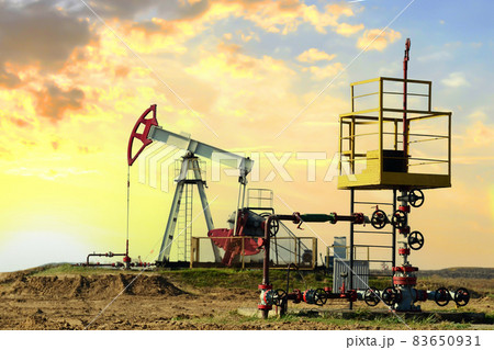 Crude oil pump jack at oilfield on sunset backround.  83650931