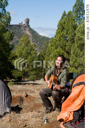 woman playing guitar among the pines woman playing guitar among the pines 83651976