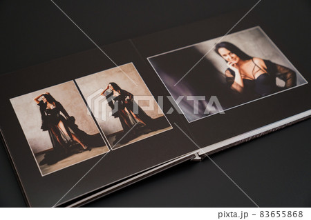 open photobook from a photo shoot of an attractive woman on a black background.  83655868