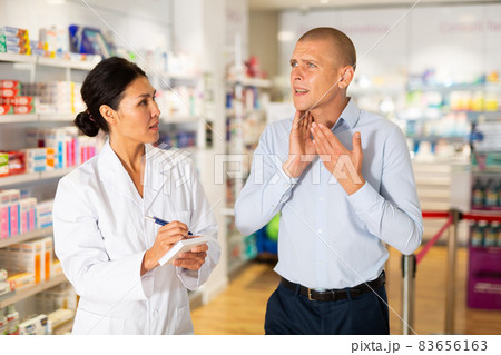 Asian female pharmacist consulting man in drugstore 83656163