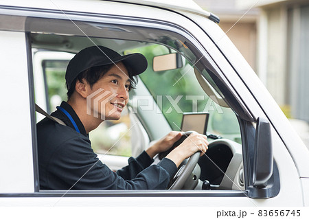 トラックを運転する爽やかなドライバー 83656745