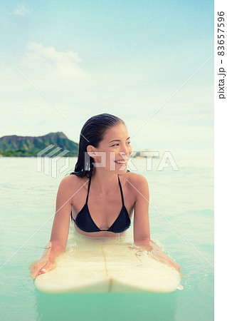 Surfer woman surfing on Waikiki Beach, Oahu, Hawaii. Female bikini girl on surfboard smiling happy living healthy active lifestyle on Hawaiian beach. Asian Caucasian model. Surfer woman surfing on Waikiki Beach, Oahu, Hawaii. Female bikini girl on surfboard smiling happy living healthy active lifestyle on Hawaiian beach. Asian Caucasian model. 83657596