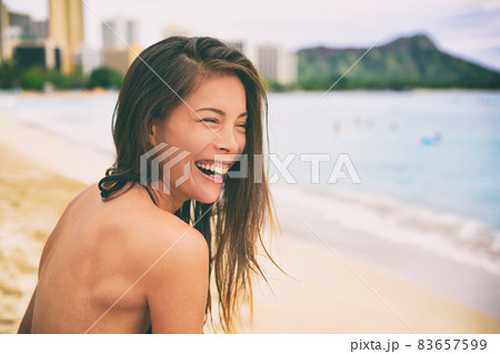 Hawaii beach vacation lifestyle laughing young Asian girl living the good life enjoying summer. Multiracial woman in bikini. Waikiki Beach, Honolulu Hawaii beach vacation lifestyle laughing young Asian girl living the good life enjoying summer. Multiracial woman in bikini. Waikiki Beach, Honolulu 83657599