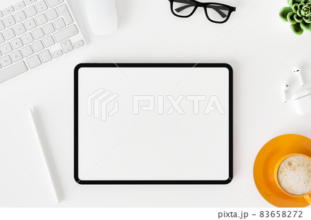 Top view of blank screen tablet on white working desk Top view of blank screen tablet on white working desk 83658272