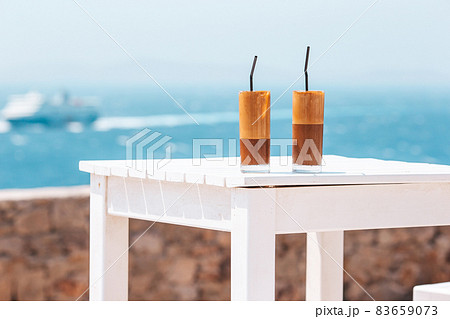 Coffee latte on wooden table with sea background Coffee latte on wooden table with sea background 83659073