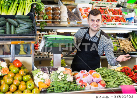 attractive male seller showing assortment of grocery shop attractive male seller showing assortment of grocery shop 83661452