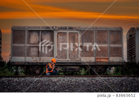 Engineer under discussion inspection and checking construction process railway switch and checking work on railroad station .Engineer wearing safety uniform and safety helmet in work. 83663652