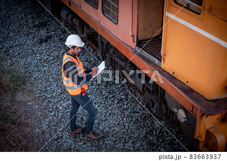 Engineer under discussion inspection and checking construction process railway switch and checking work on railroad station .Engineer wearing safety uniform and safety helmet in work. Engineer under discussion inspection and checking construction process railway switch and checking work on railroad station .Engineer wearing safety uniform and safety helmet in work. 83663937